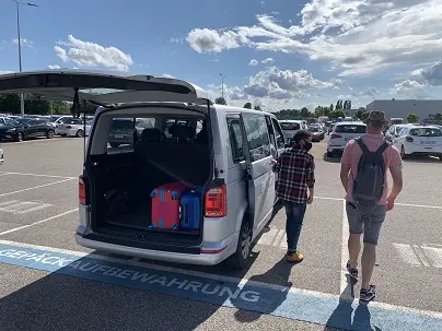 Clients chargeant leurs bagages dans une navette BluePark